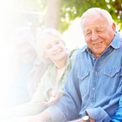 Four seniors sitting down and sharing a laugh outdoors